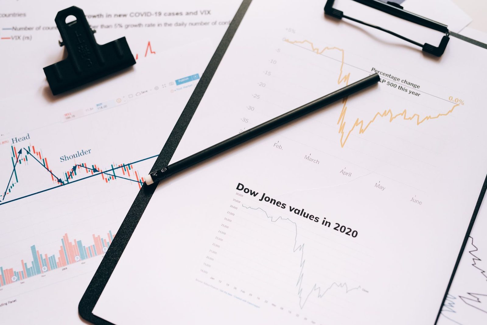 A clipboard holding a printed index chart with a pen resting across it