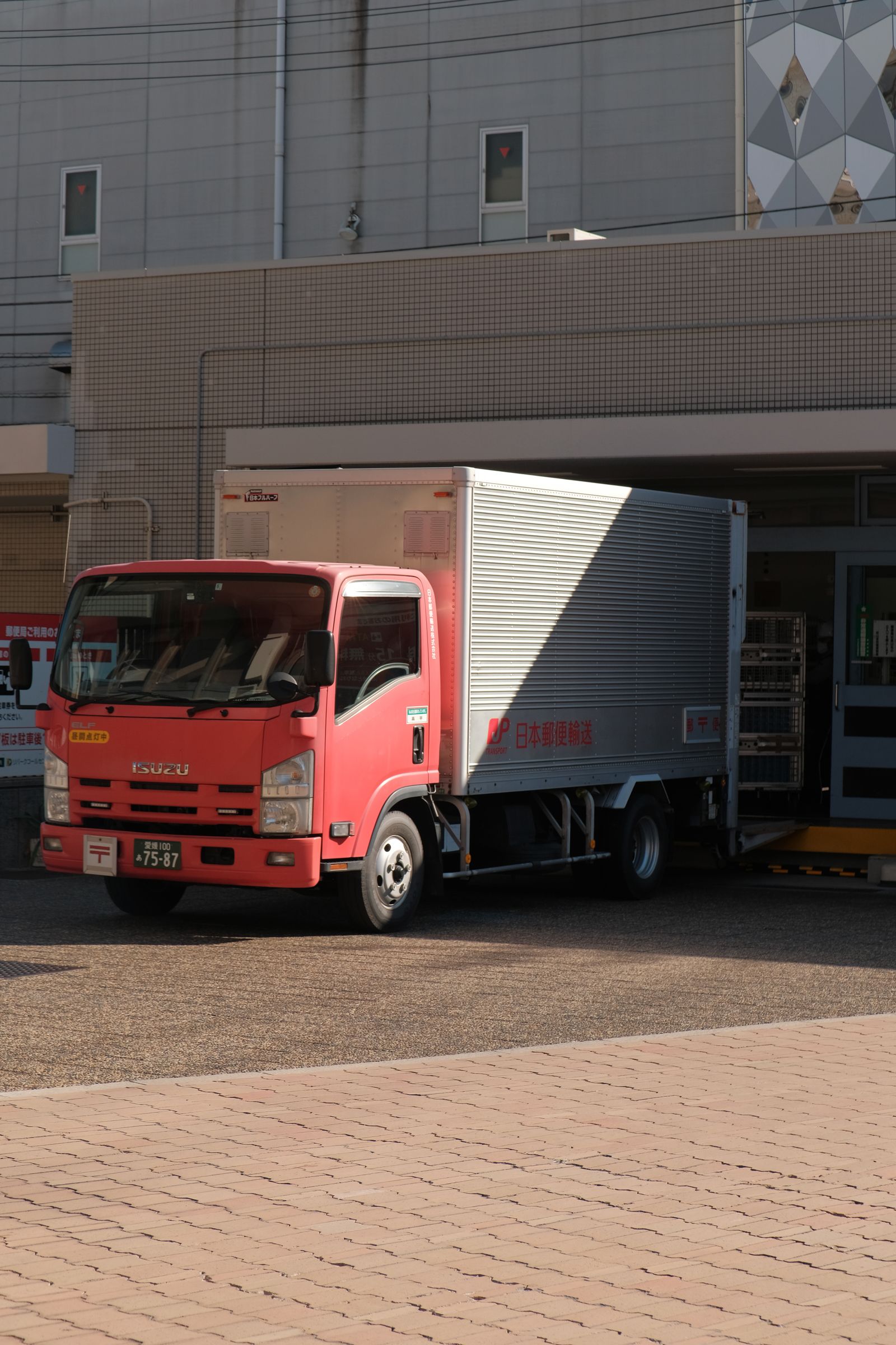 Delivery truck backed up to a warehouse loading dock, the kind of load that generates the invoice a freight factor advances against