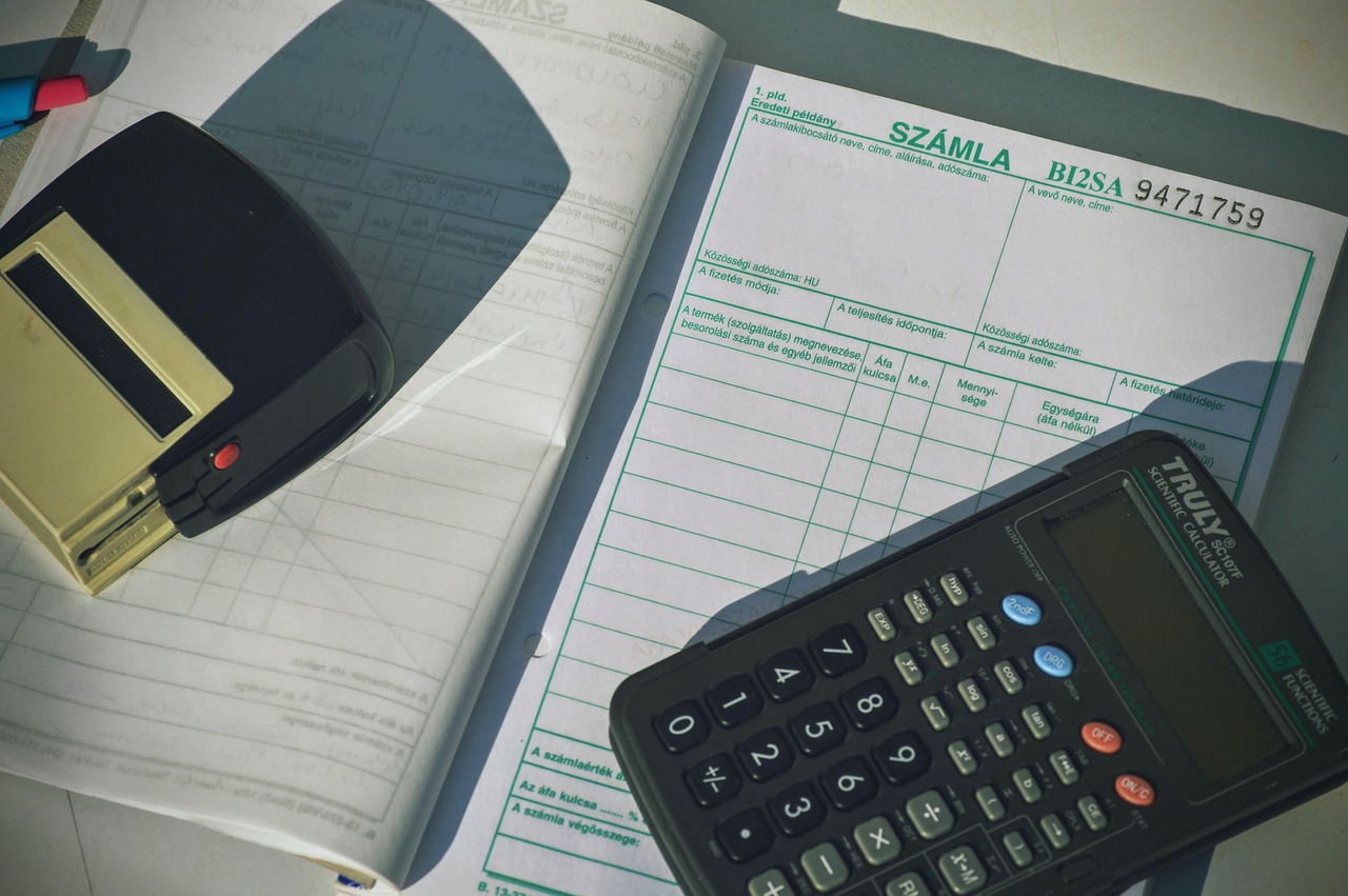 Calculator sitting on top of a stack of paper invoices, used to work out a factoring discount rate