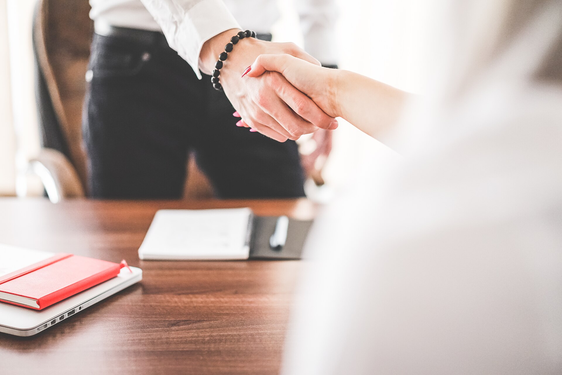 Business owner and client shaking hands after agreeing on payment terms