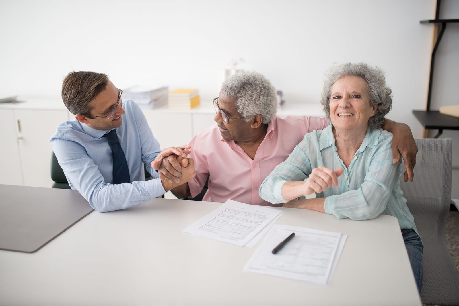 An adviser sitting across a table from an older couple with documents between them