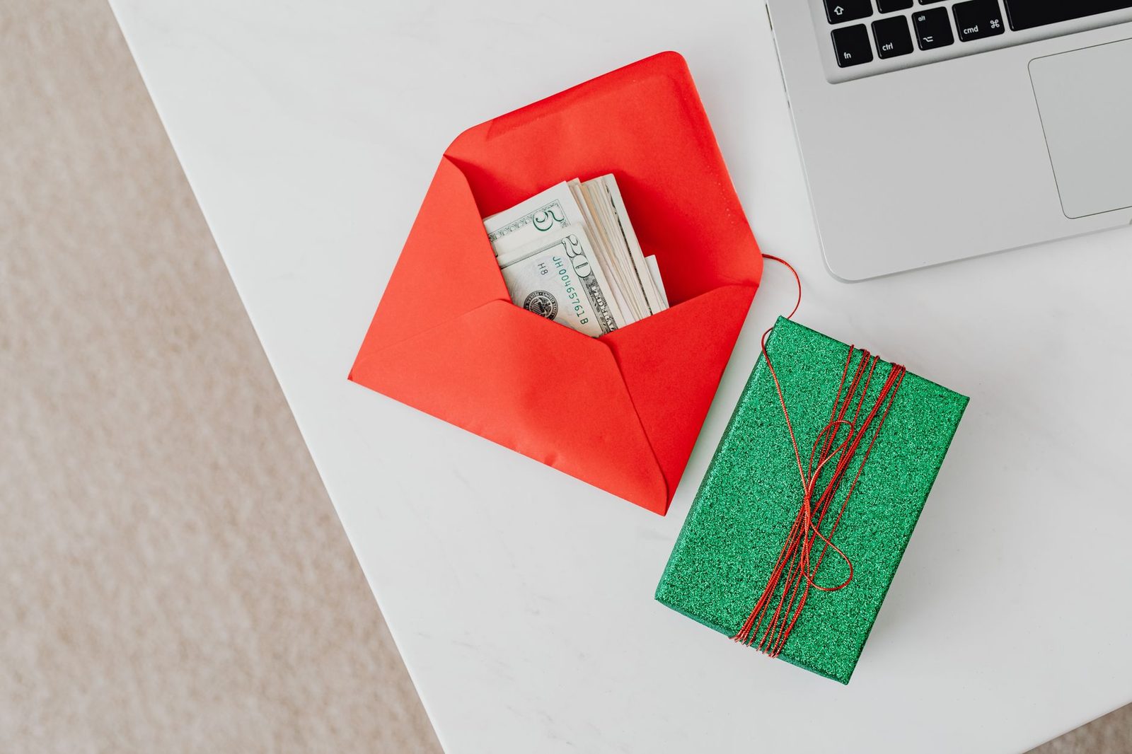 A red envelope of banknotes next to a green notebook on a desk