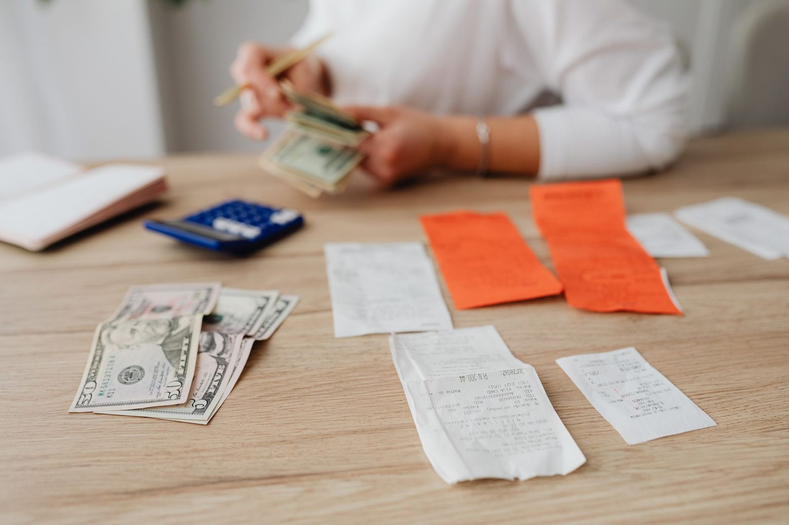Banknotes, receipts and a calculator spread across a table